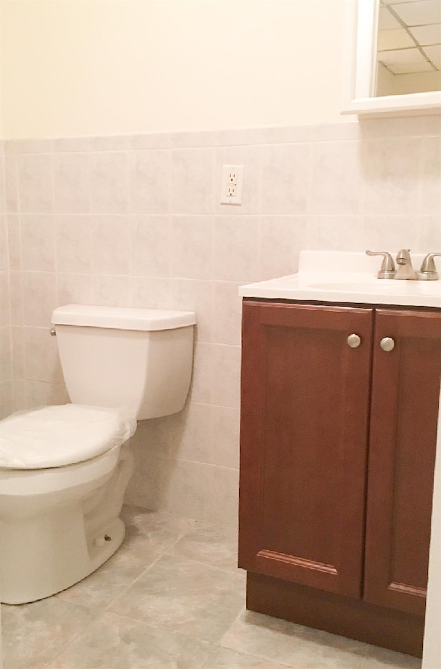 bathroom featuring tile patterned floors, vanity, and tile walls