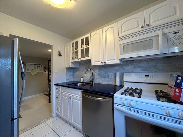 kitchen featuring white cabinets, light tile patterned floors, sink, and appliances with stainless steel finishes