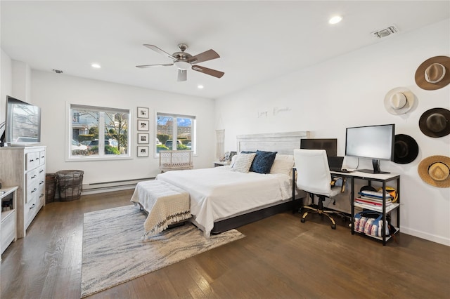 bedroom featuring ceiling fan, dark wood-type flooring, and a baseboard heating unit