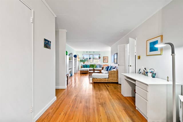 interior space featuring built in desk, light hardwood / wood-style floors, and ornamental molding