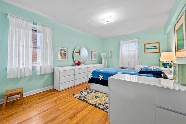 bedroom featuring multiple windows and light wood-type flooring