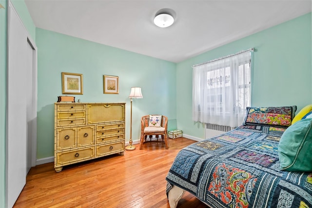 bedroom with radiator and light hardwood / wood-style flooring