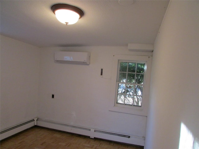 spare room with parquet flooring, a textured ceiling, an AC wall unit, and a baseboard heating unit