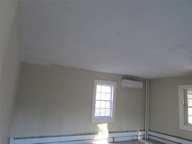 unfurnished room featuring baseboard heating and an AC wall unit