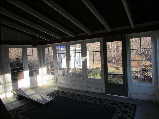 unfurnished sunroom featuring vaulted ceiling with beams