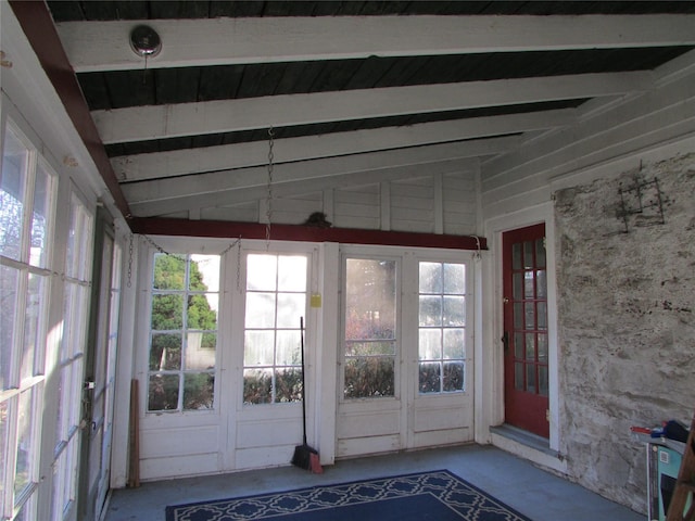 unfurnished sunroom with vaulted ceiling with beams