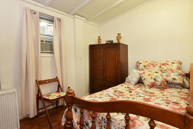 bedroom featuring radiator heating unit, dark hardwood / wood-style floors, vaulted ceiling, and cooling unit