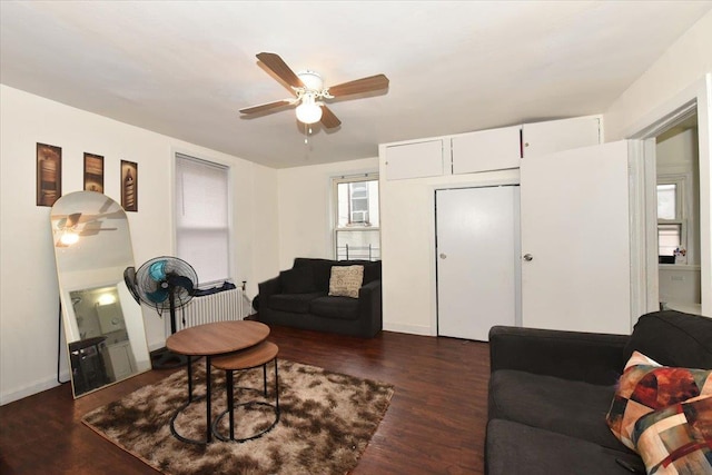 living room featuring radiator heating unit, ceiling fan, and dark wood-type flooring