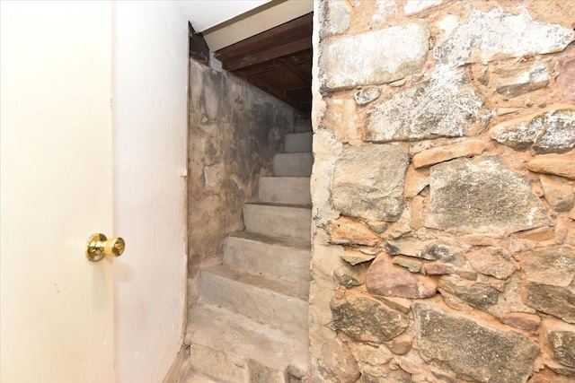 stairway featuring beam ceiling