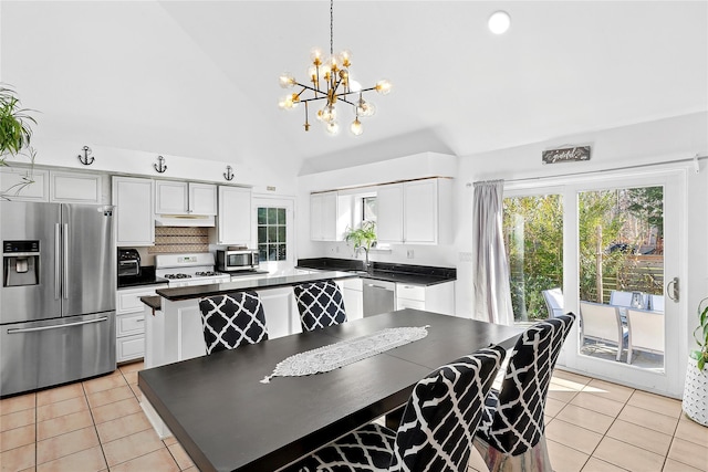 20 Walton St, Springs, NY 11937 - kitchen featuring stainless steel appliances, light tile patterned floors, under cabinet range hood, a chandelier, and dark countertops