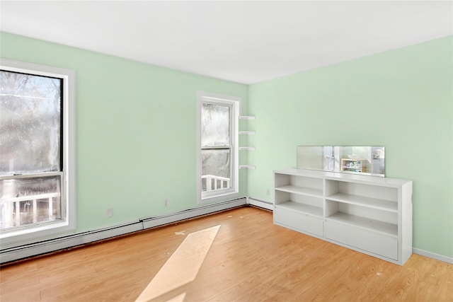 unfurnished room featuring hardwood / wood-style floors and baseboard heating