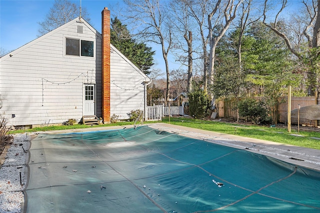 view of swimming pool featuring a yard