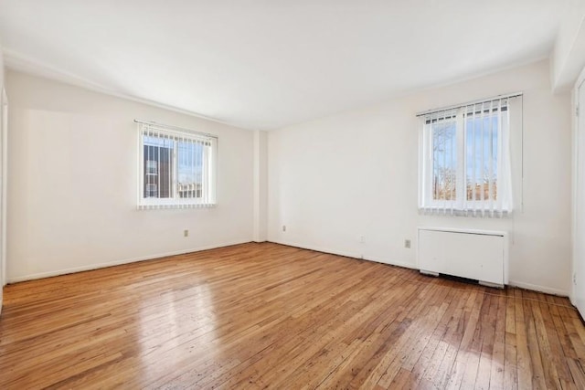 empty room with radiator heating unit and light wood-type flooring