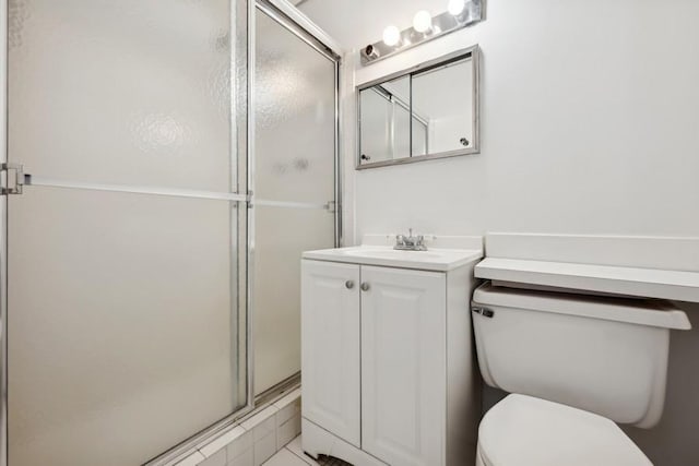 bathroom featuring vanity, toilet, and a shower with shower door