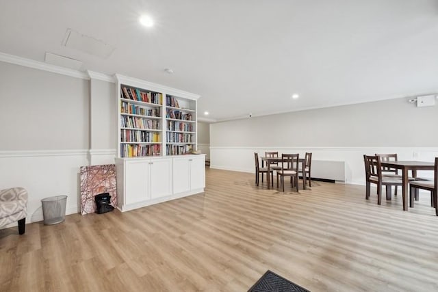 sitting room with ornamental molding and light wood-type flooring