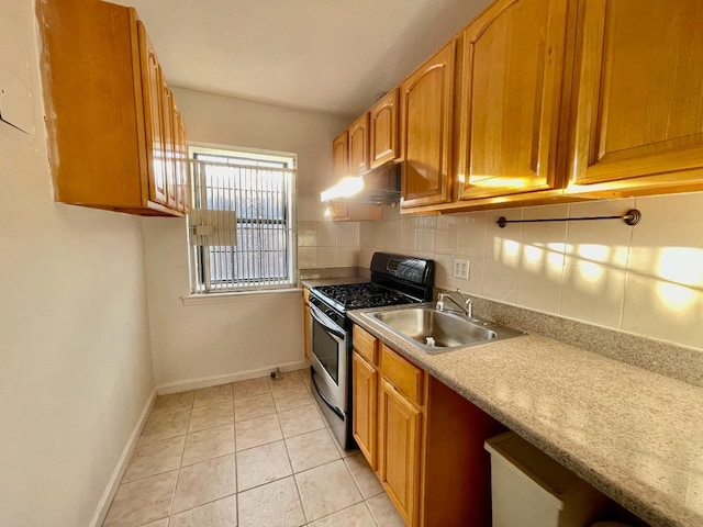 kitchen with stainless steel gas stove, sink, light tile patterned floors, and backsplash