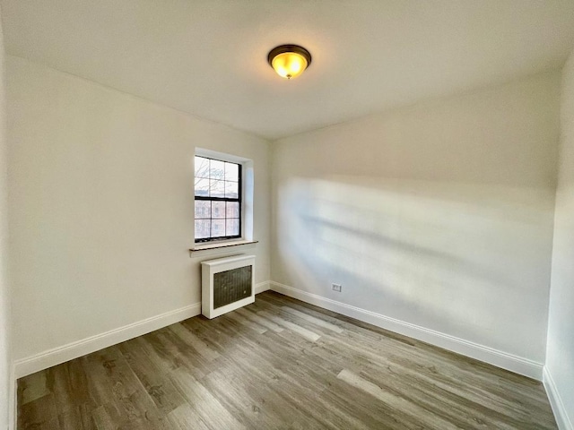 spare room featuring hardwood / wood-style flooring and radiator