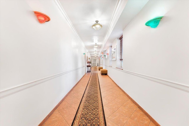 corridor featuring light tile patterned flooring and ornamental molding