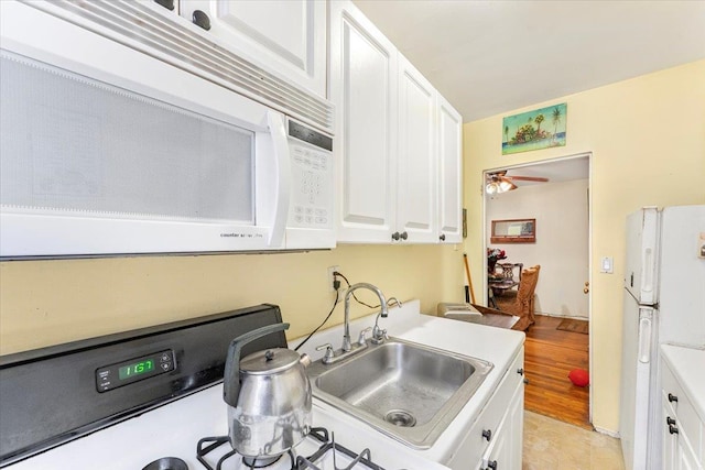 kitchen featuring light hardwood / wood-style floors, ceiling fan, white cabinetry, and white appliances