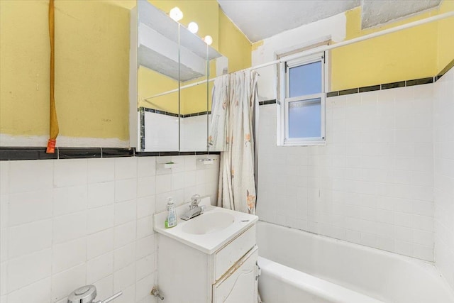 bathroom featuring shower / bath combo, tile walls, and vanity