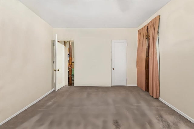 spare room featuring dark colored carpet