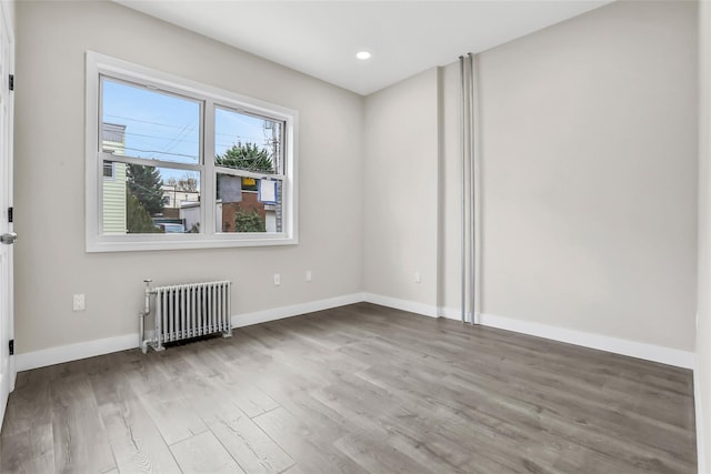 spare room with hardwood / wood-style flooring and radiator heating unit