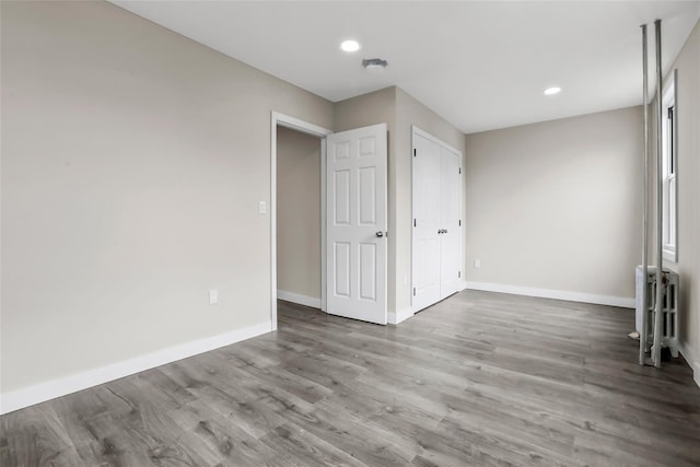 unfurnished room with radiator and hardwood / wood-style flooring