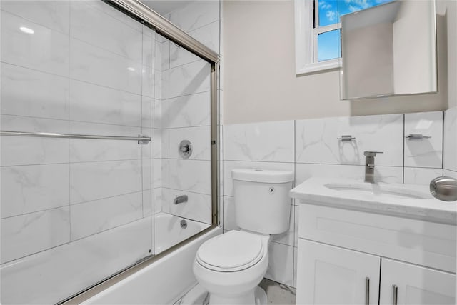 full bathroom with shower / bath combination with glass door, vanity, tile walls, and toilet