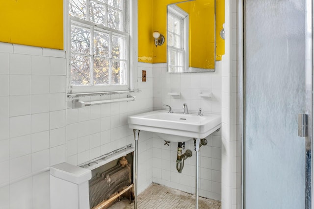 bathroom featuring radiator heating unit and tile walls