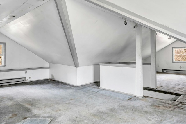 additional living space featuring carpet floors, vaulted ceiling, and a baseboard heating unit