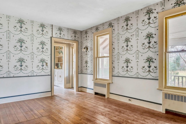 empty room with light hardwood / wood-style flooring and radiator