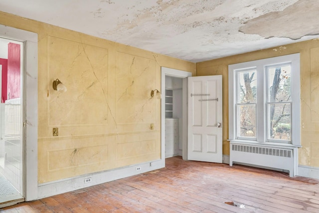 interior space with radiator heating unit and wood-type flooring