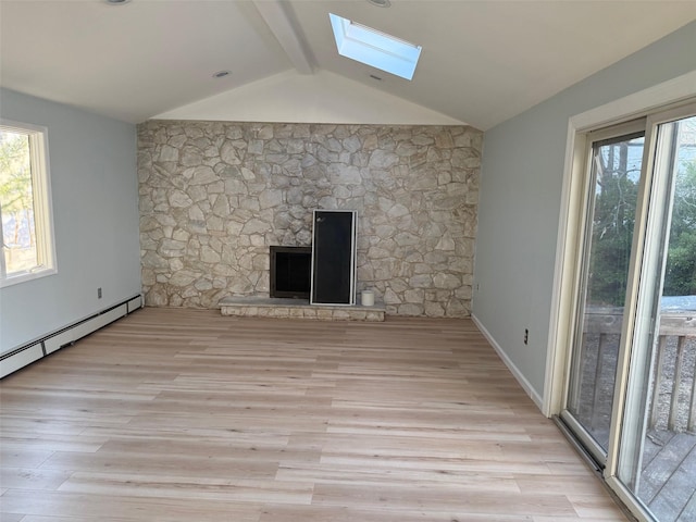 unfurnished living room featuring vaulted ceiling with skylight, light hardwood / wood-style floors, baseboard heating, and a fireplace