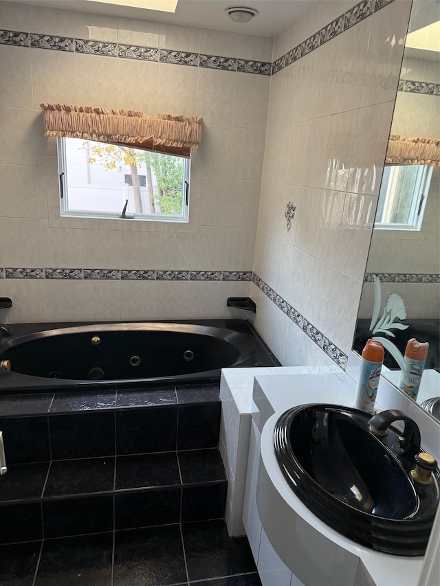 bathroom featuring sink, tile patterned floors, tile walls, and tiled tub