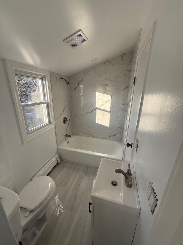 full bathroom with vanity, toilet, baseboard heating, and tiled shower / bath combo