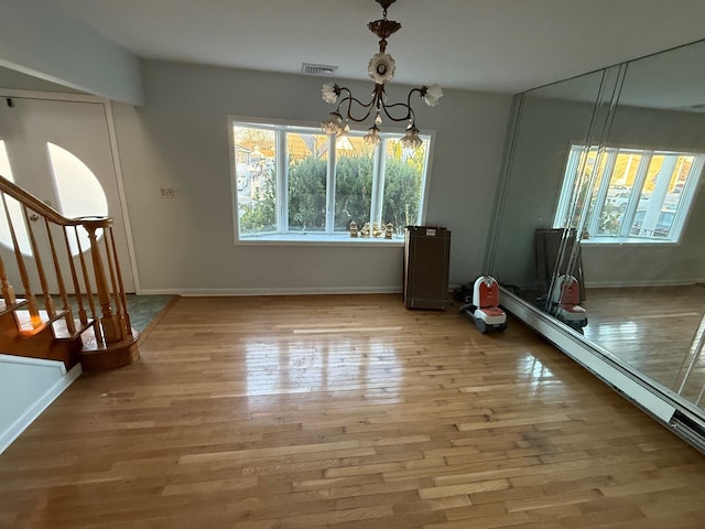 unfurnished dining area with hardwood / wood-style flooring and an inviting chandelier