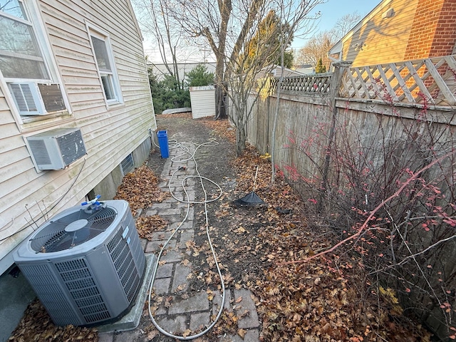 view of yard featuring an AC wall unit, cooling unit, and central AC unit