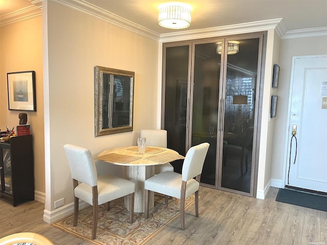 dining room with light wood-type flooring and ornamental molding