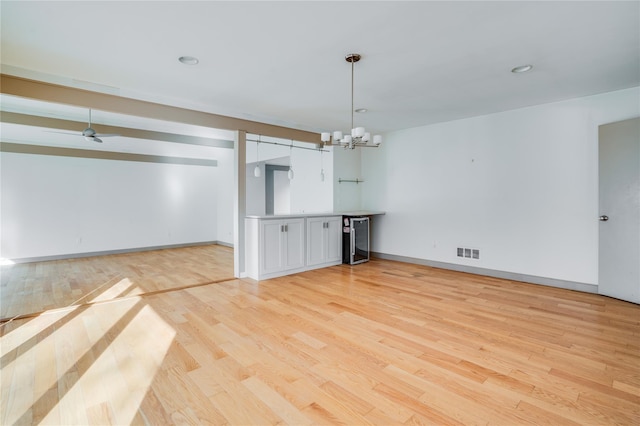 interior space featuring light hardwood / wood-style floors, wine cooler, and a chandelier