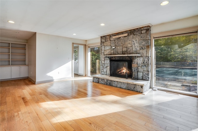 unfurnished living room with a fireplace and light wood-type flooring