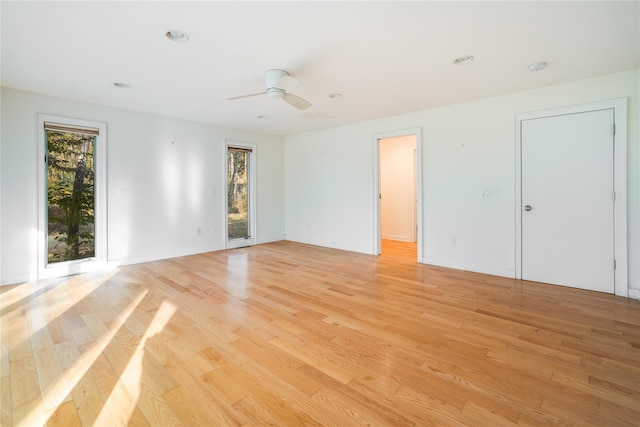 unfurnished room featuring plenty of natural light, ceiling fan, and light hardwood / wood-style flooring