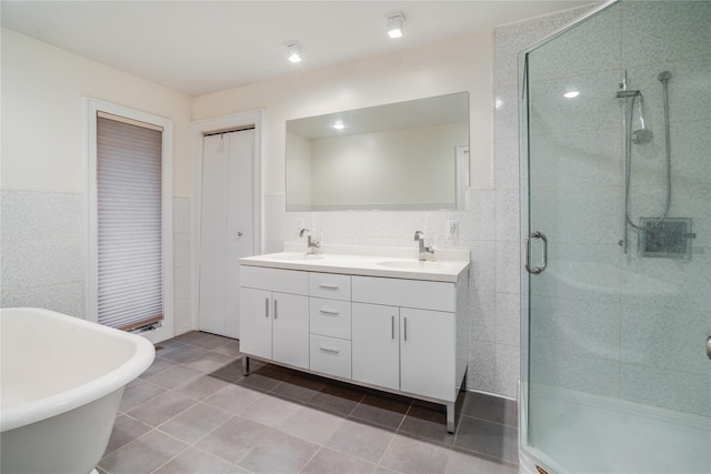 bathroom with tile patterned flooring, vanity, tile walls, and shower with separate bathtub