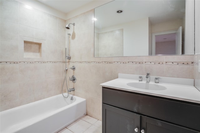 bathroom featuring tile patterned floors, vanity, tile walls, and tiled shower / bath