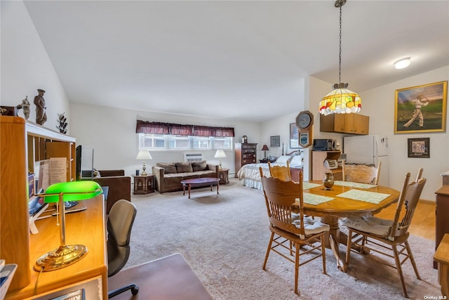 carpeted dining area featuring vaulted ceiling