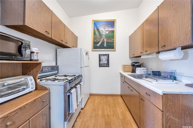 kitchen featuring light hardwood / wood-style floors, white range with gas cooktop, and vaulted ceiling