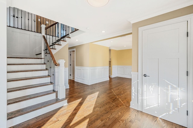 stairs featuring wood-type flooring and crown molding