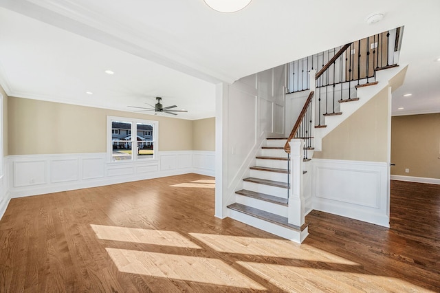 stairway with hardwood / wood-style flooring, ceiling fan, and ornamental molding