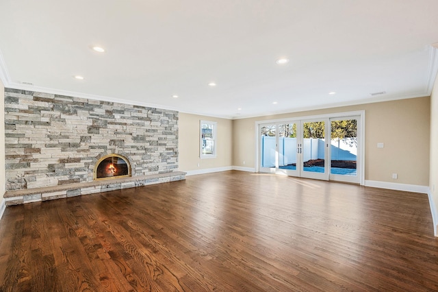 unfurnished living room with hardwood / wood-style floors, a healthy amount of sunlight, and crown molding