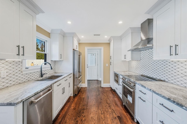 kitchen with white cabinets, dark hardwood / wood-style floors, high quality appliances, and wall chimney range hood