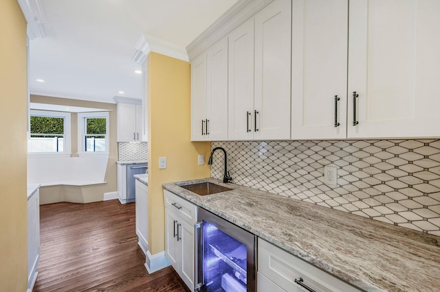 kitchen with white cabinets, dark hardwood / wood-style flooring, beverage cooler, and sink